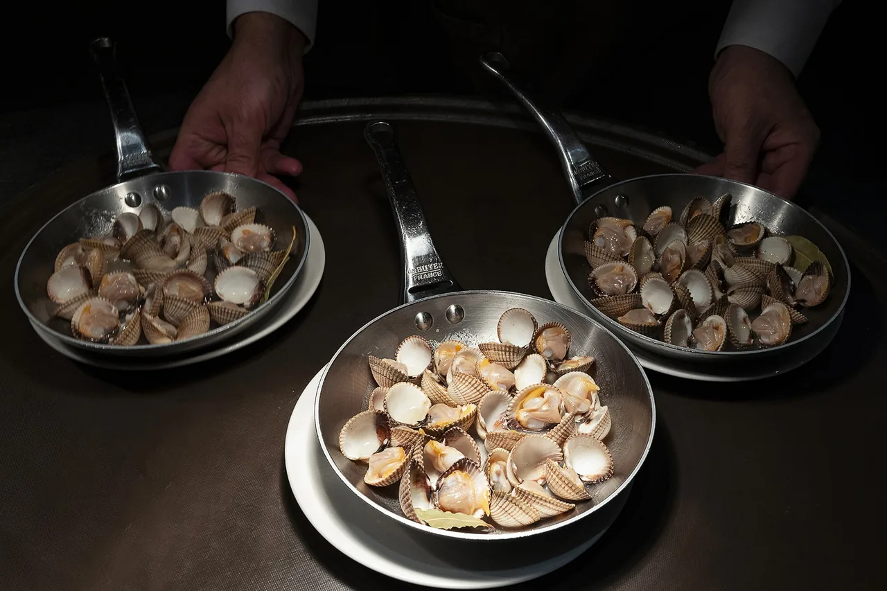 Three metal pans of steamed clams