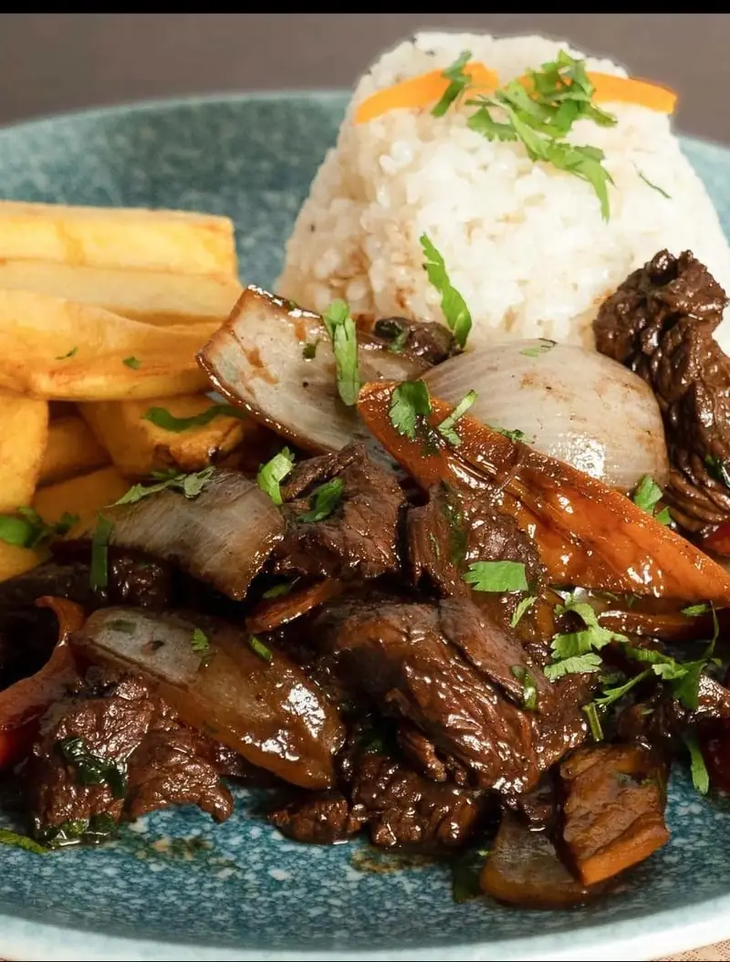 Lomo saltado stir-fried beef with onion and carrot, served with rice and fries, El Señorío de Perú
