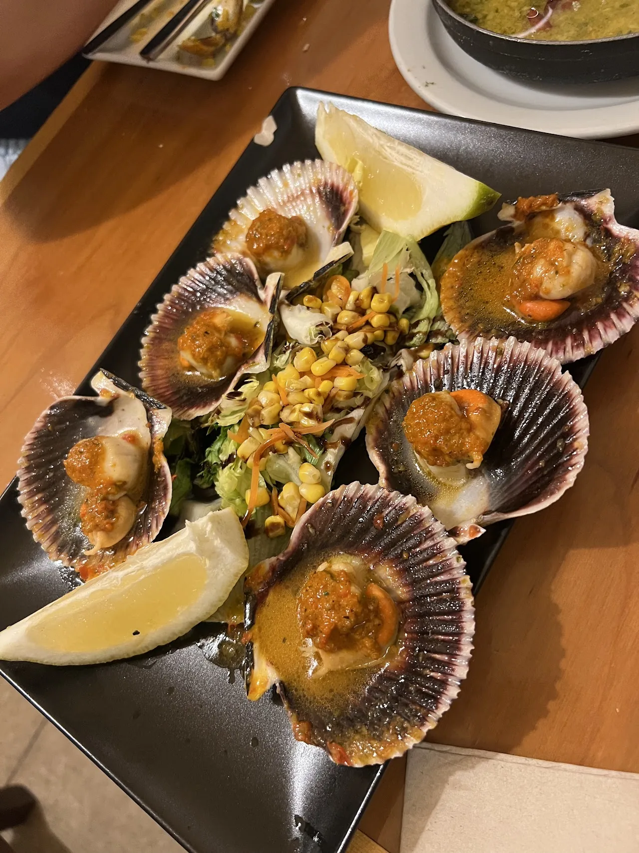 Grilled scallops in their shells with a corn garnish
