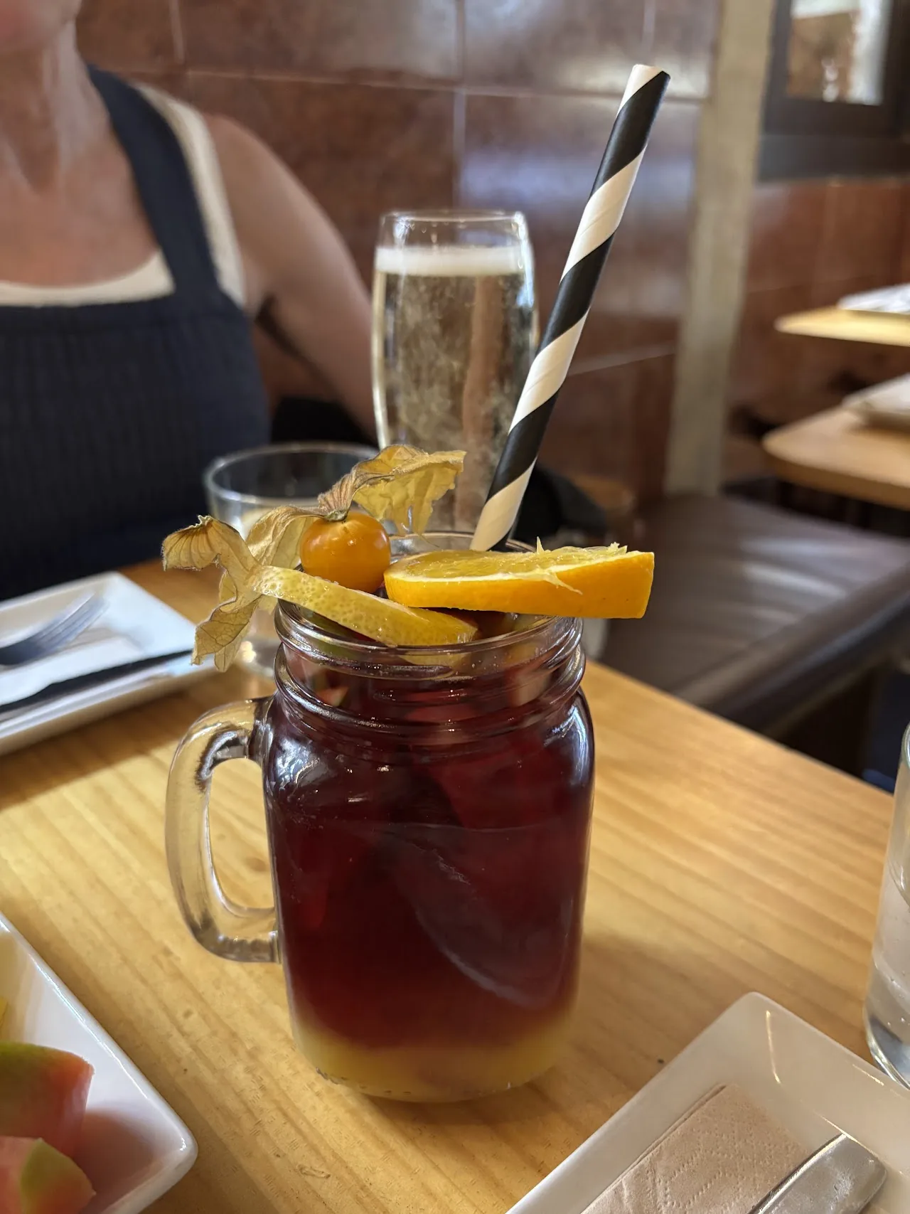 A glass of sangria with orange slices and straws