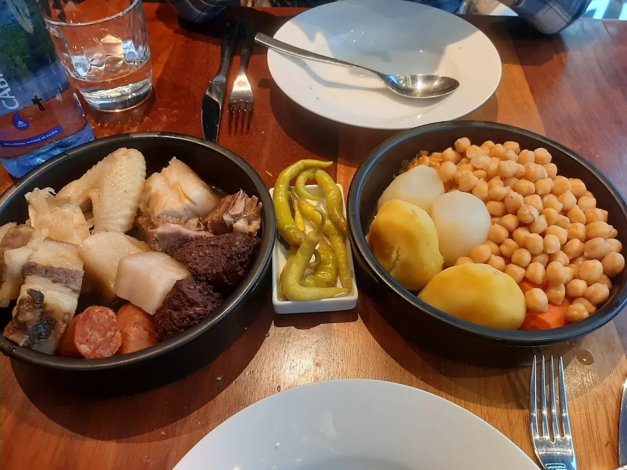 A charcuterie board with cheese, pickles, and chickpeas