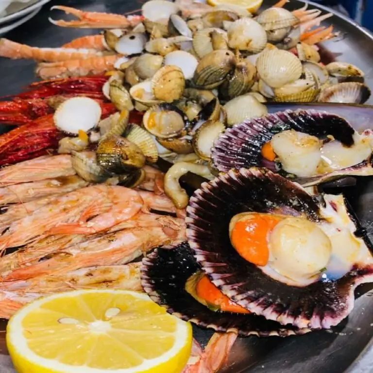 Seafood platter with scallops in the shell, cockles, prawns, langoustines and a lemon half