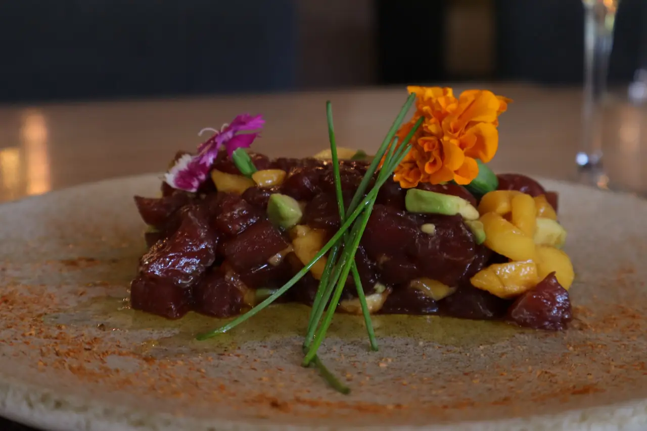 Bluefin tuna tartare with mango and avocado, topped with chives and edible flowers