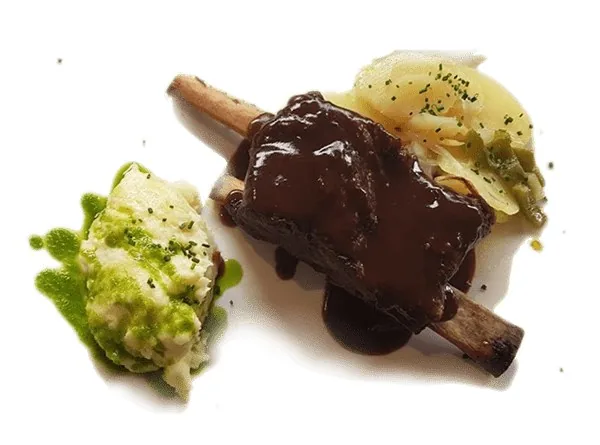 A braised short rib on the bone under a glossy dark reduction, served with a green herb-flecked potato mash and sliced potato with parsley