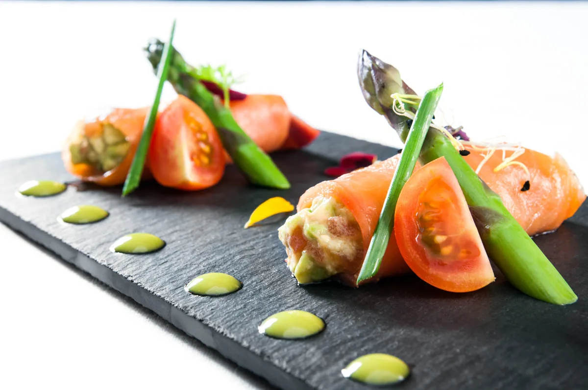 A plated dish with tomato, asparagus, and shrimp