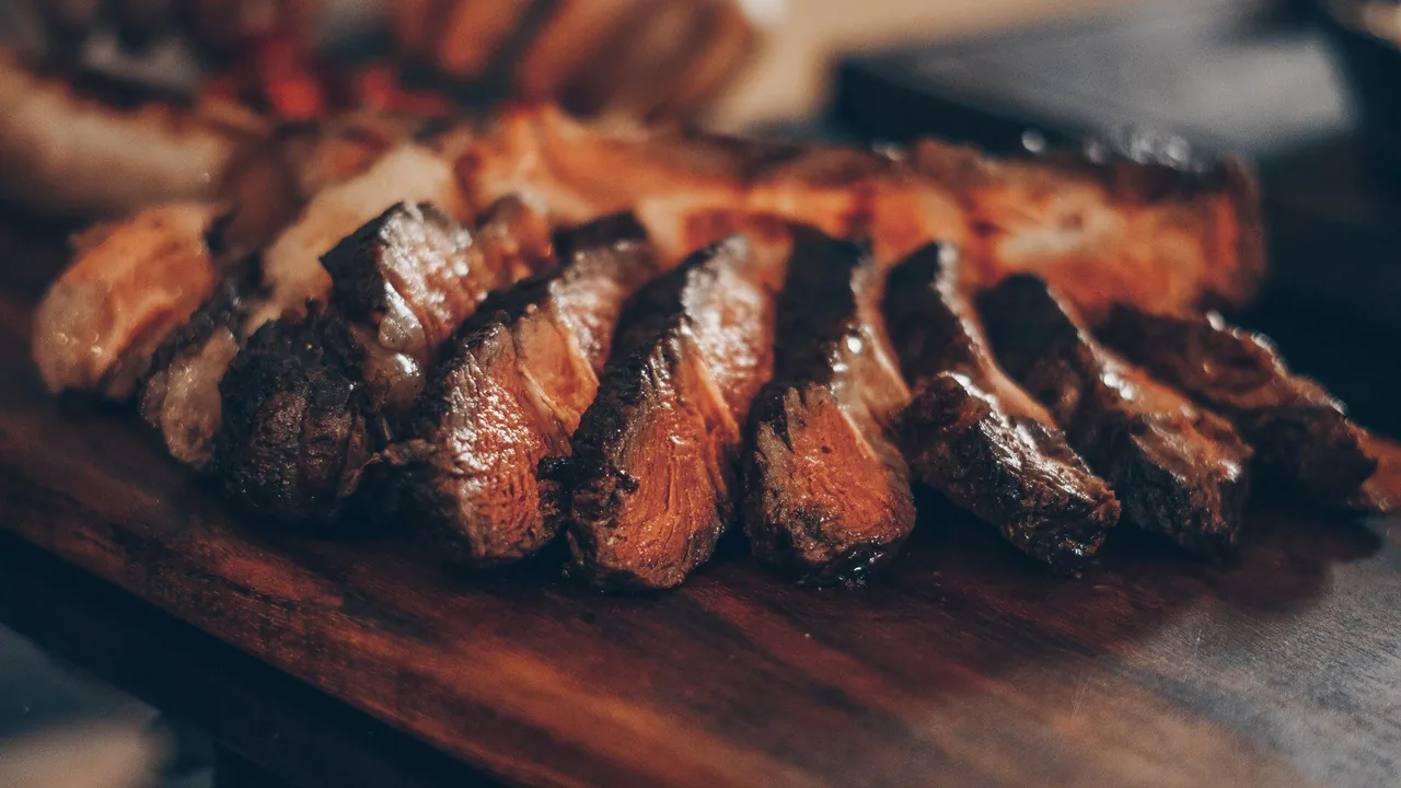 Sliced grilled beef on a wooden board