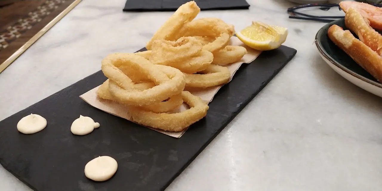 Fried calamari rings served on a board with aioli, at Elisabets.