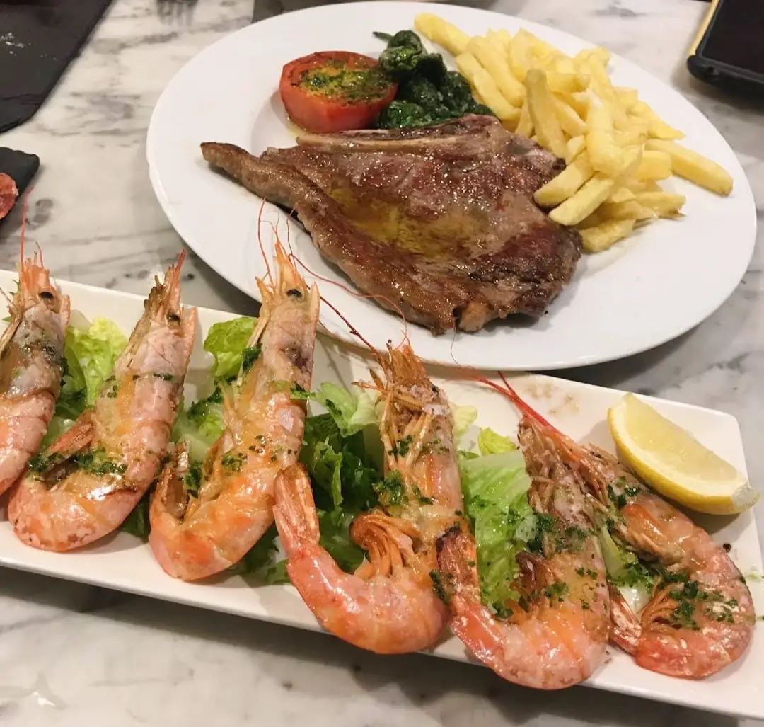 Platter of grilled lamb chops and prawns with fries and salad, at Elisabets.