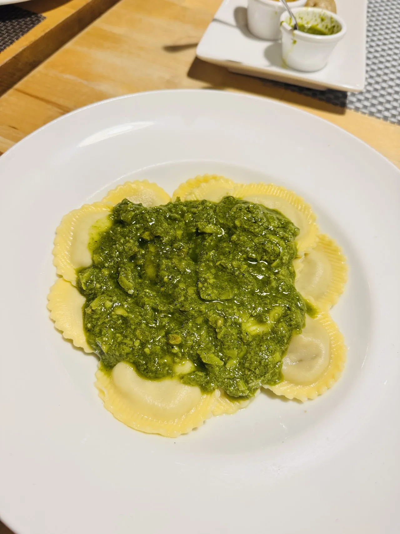 A plate of pasta coated in green pesto sauce