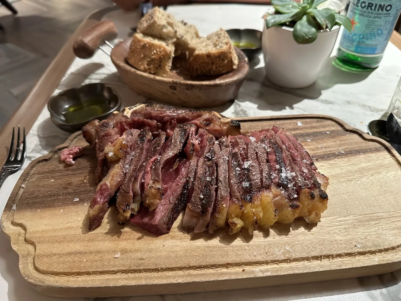 Sliced steak fanned out on a wooden board