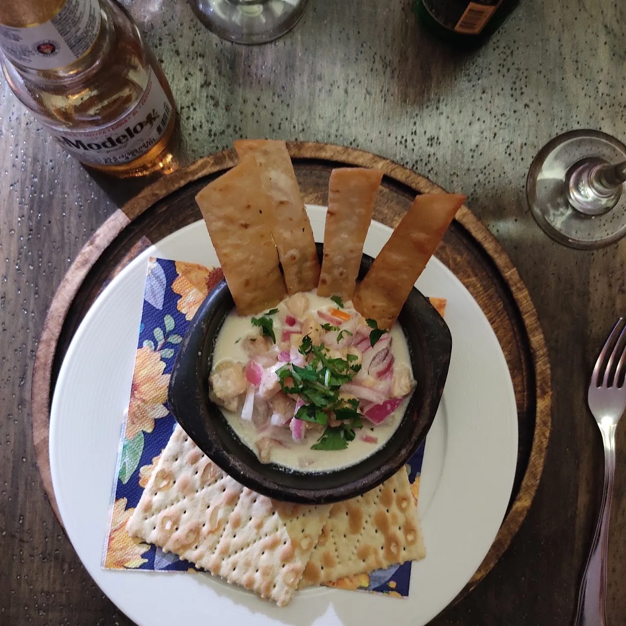 A ceviche dish with tortilla strips and micro greens, top-down view