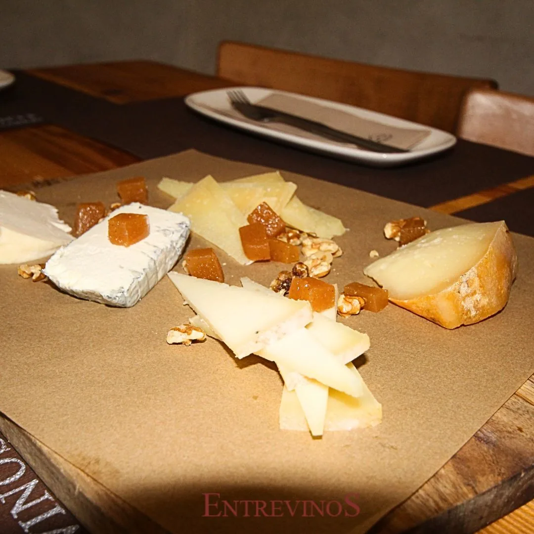 An assorted cheese board with nuts and honey