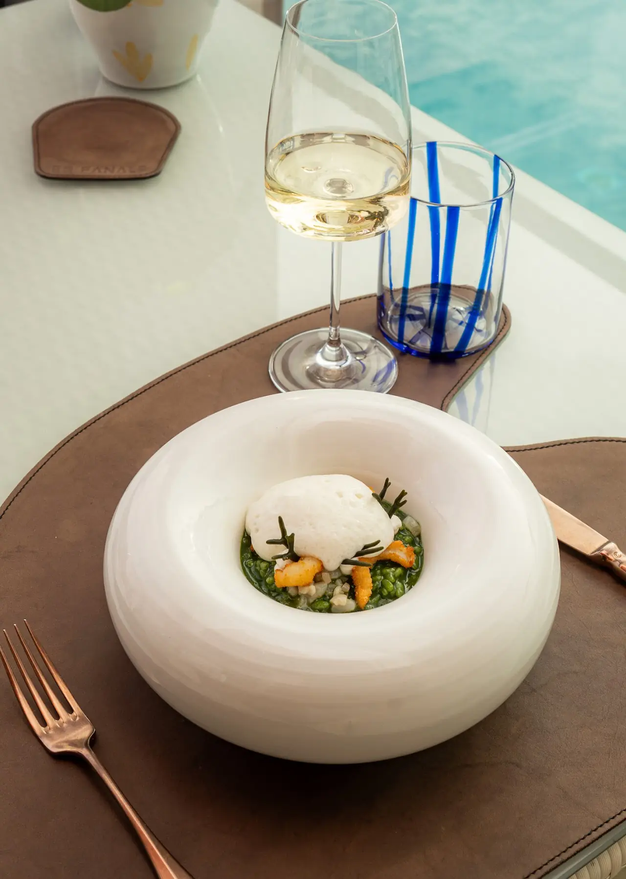 A seafood and herb dish served in a round white ceramic bowl.