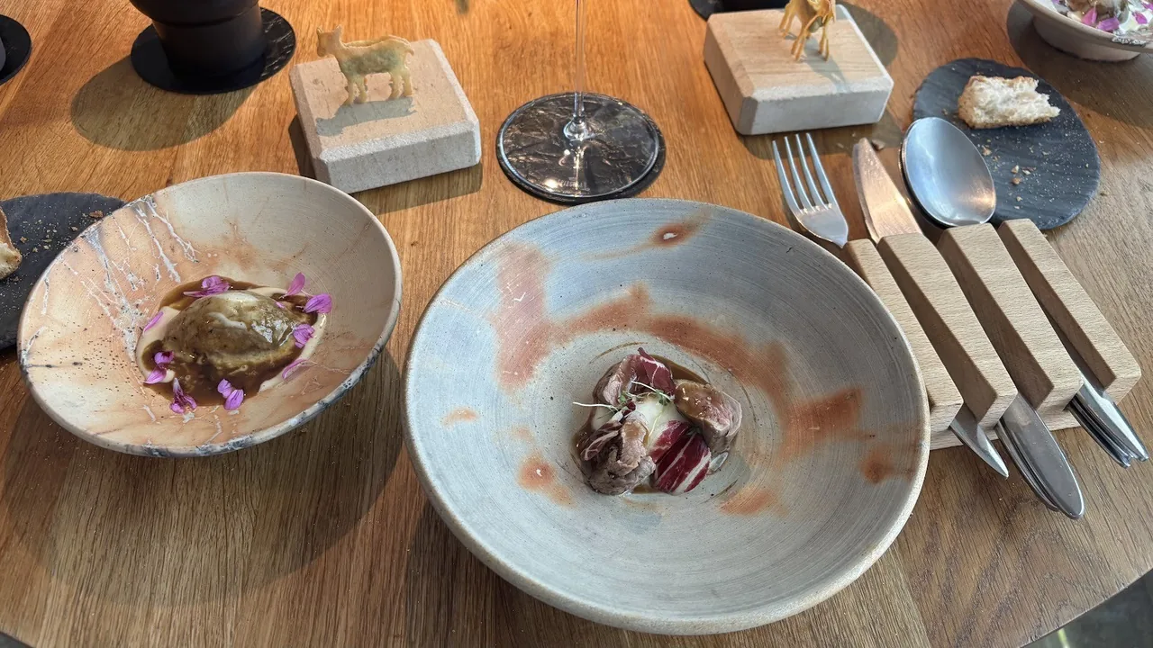 Two ceramic bowls of small composed dishes on a wooden table
