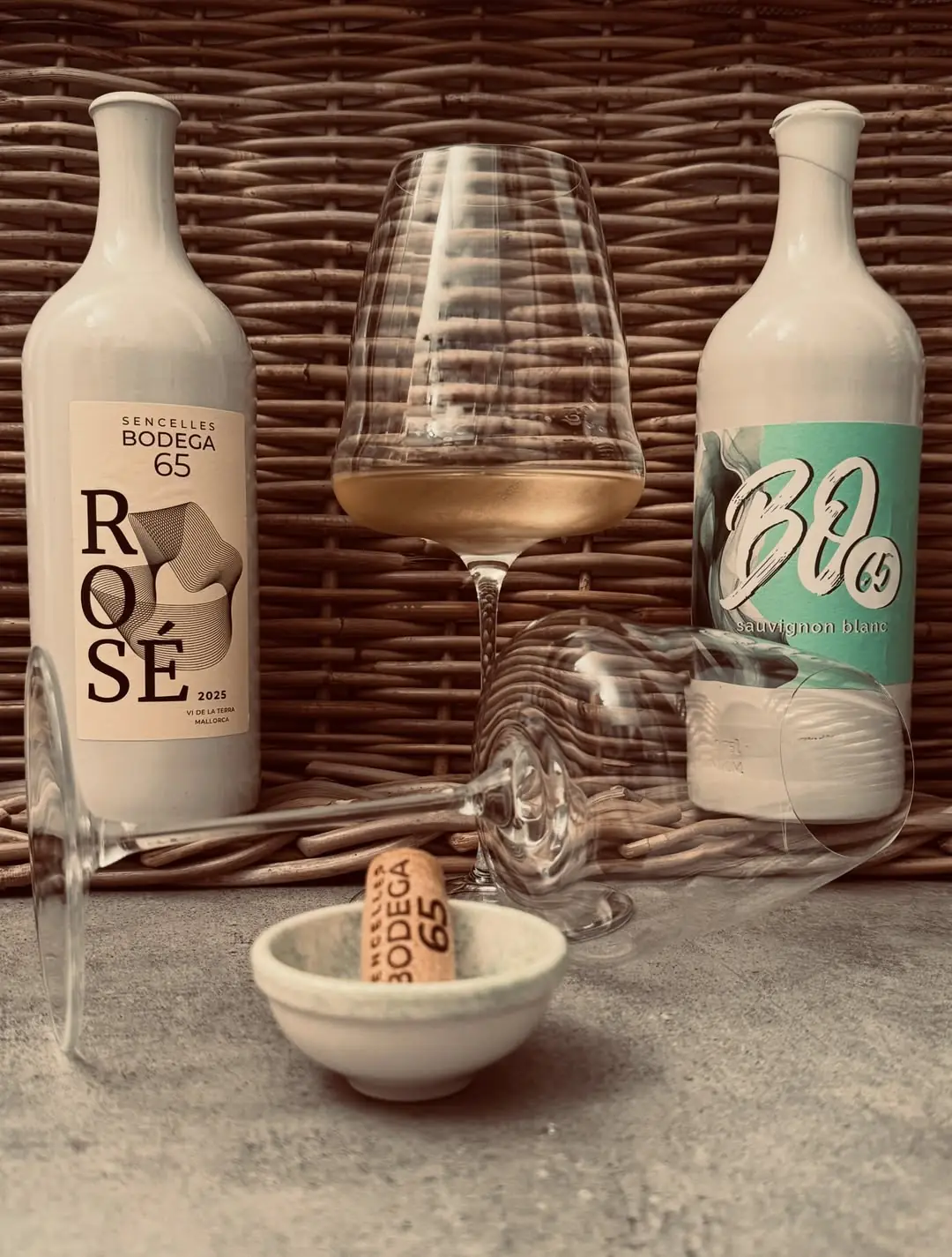 Bodega 65 rosé and white wine bottles with a glass of rosé