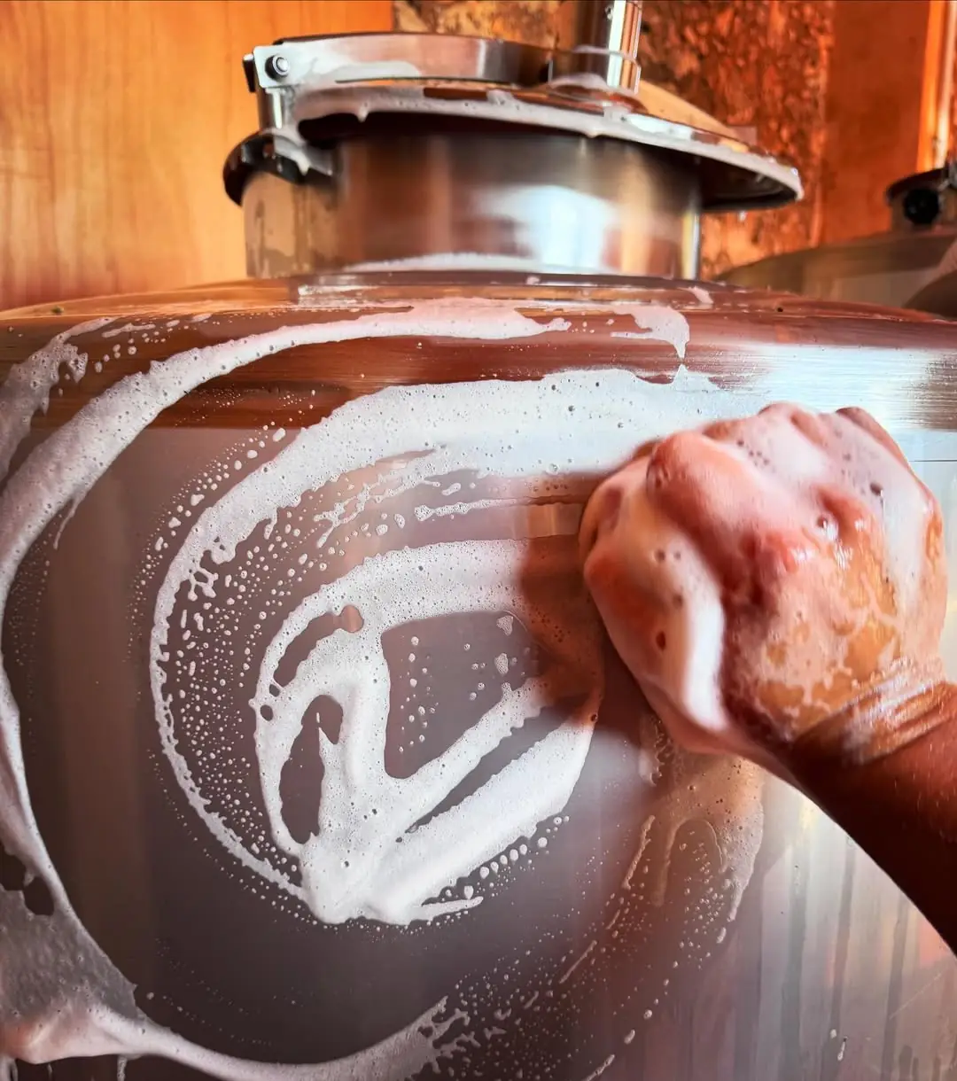 Punching down fermenting grapes in a barrel at Microceller Son Crespí