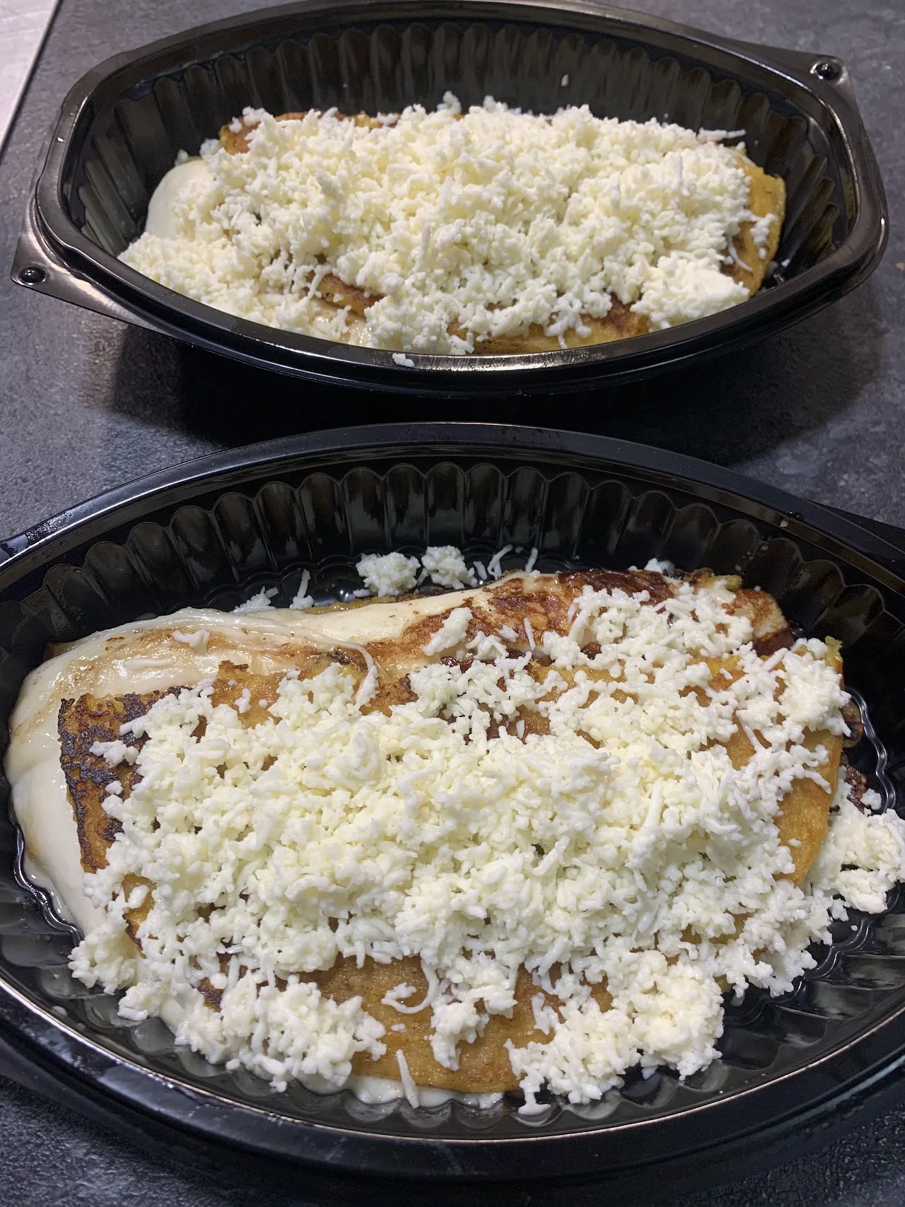 Two bowls of a saucy stew topped with shredded cheese