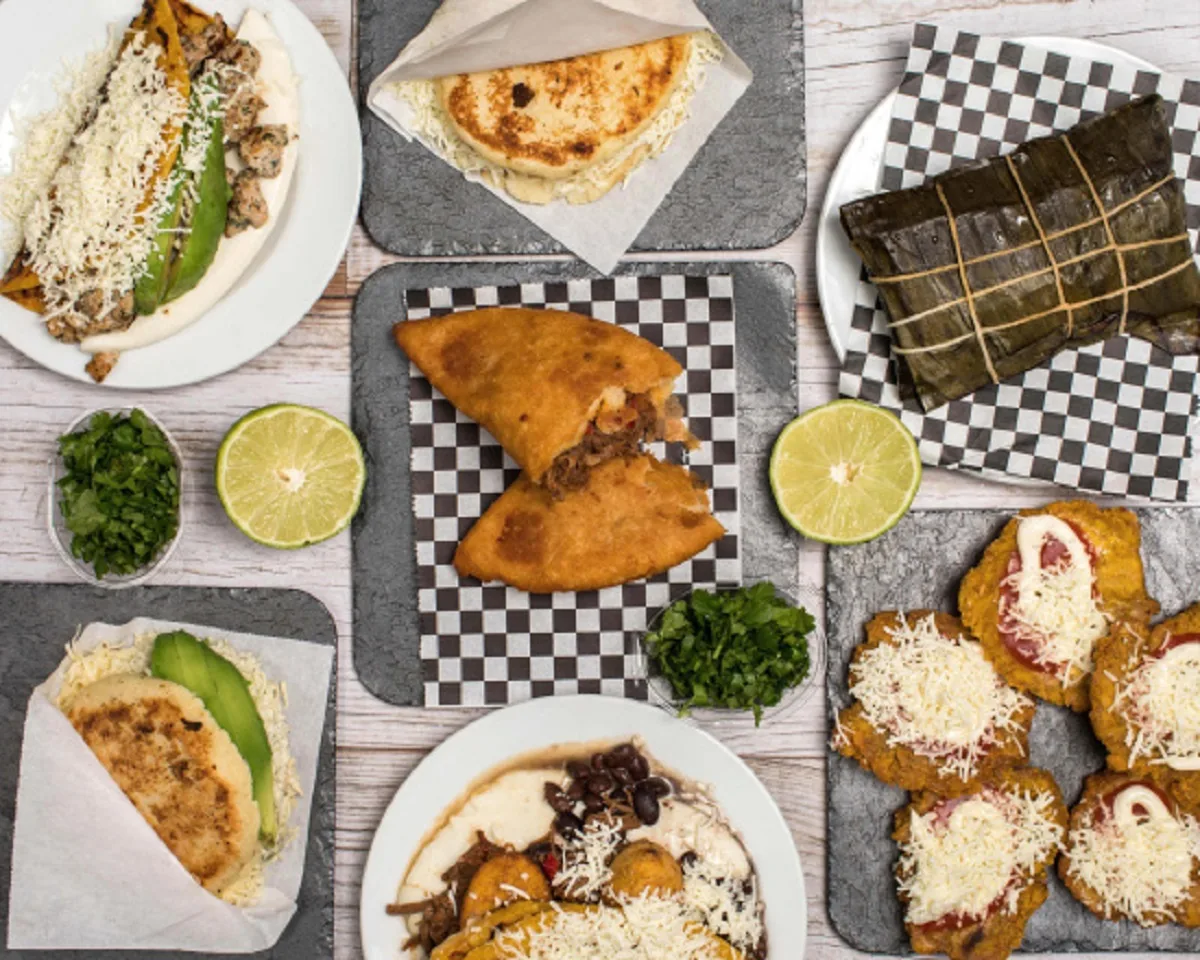An overhead spread of tacos, quesadillas, and tamales with lime wedges