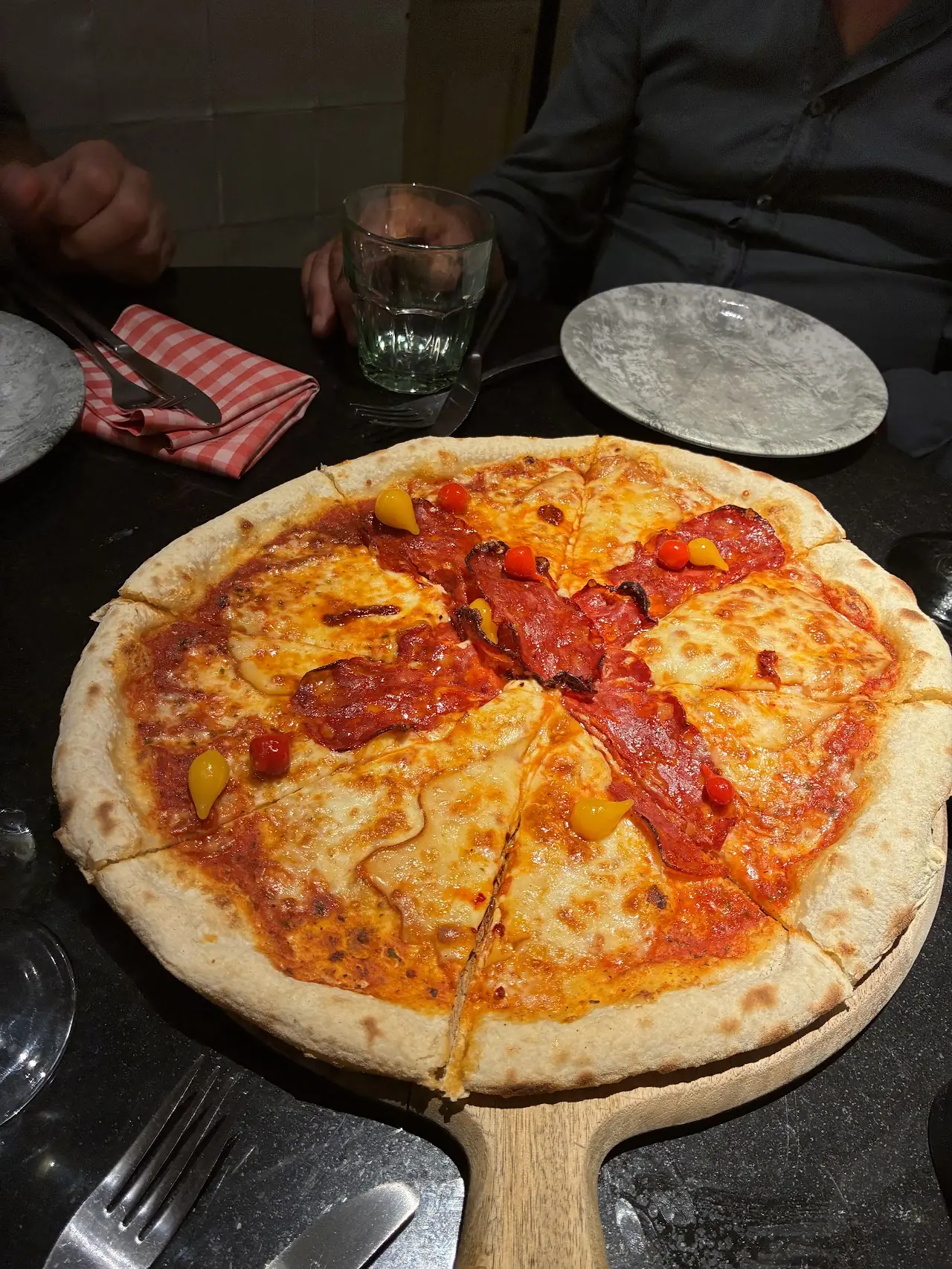 A pepperoni pizza on a wooden pizza peel.