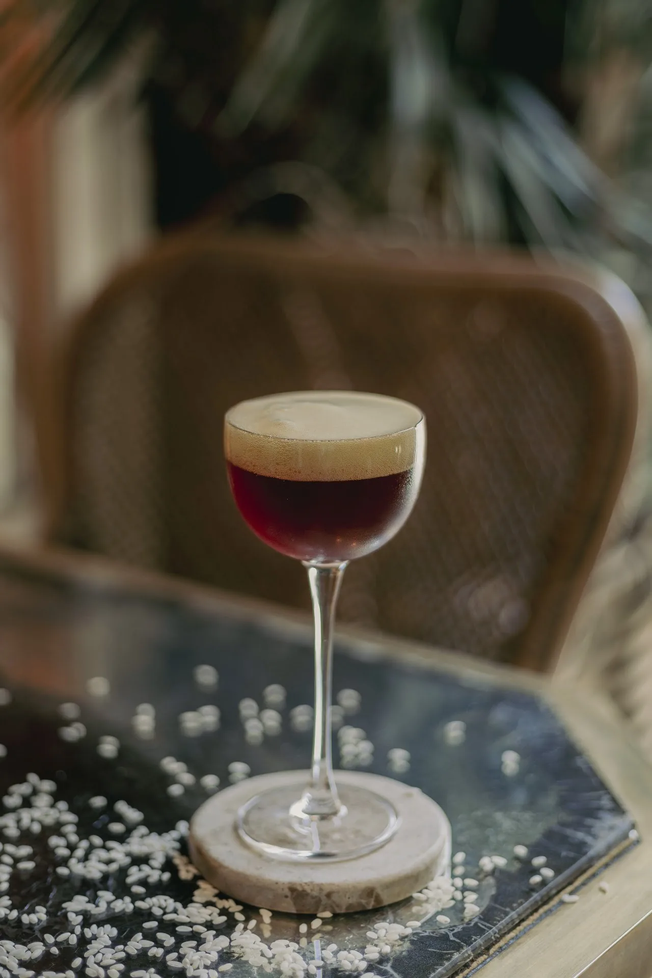 An espresso martini with a light foam top in a coupe glass