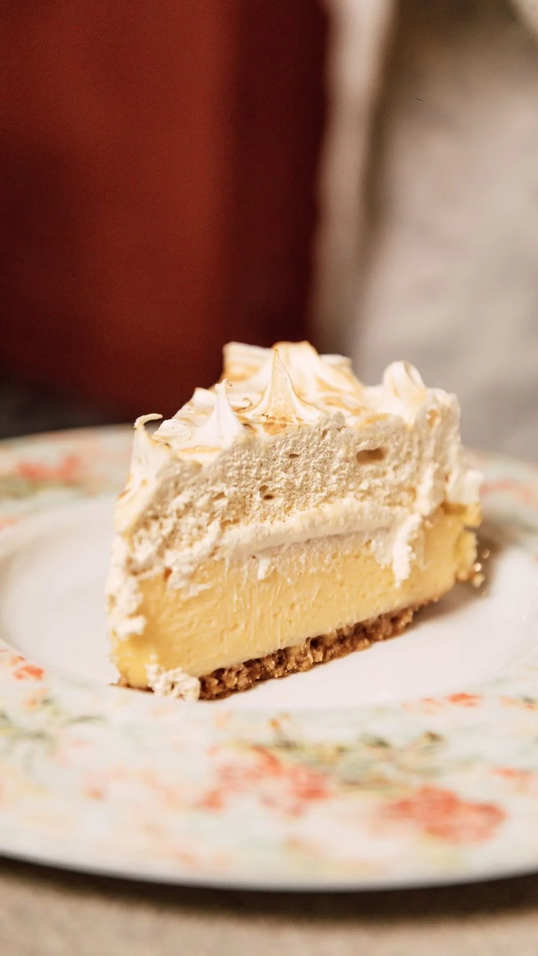 A slice of layered cream cake on a floral plate