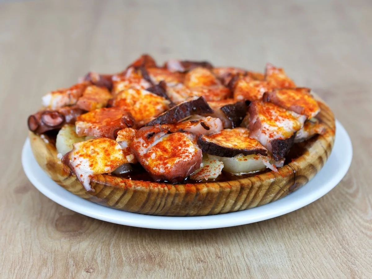 Octopus with potatoes and paprika on a round plate
