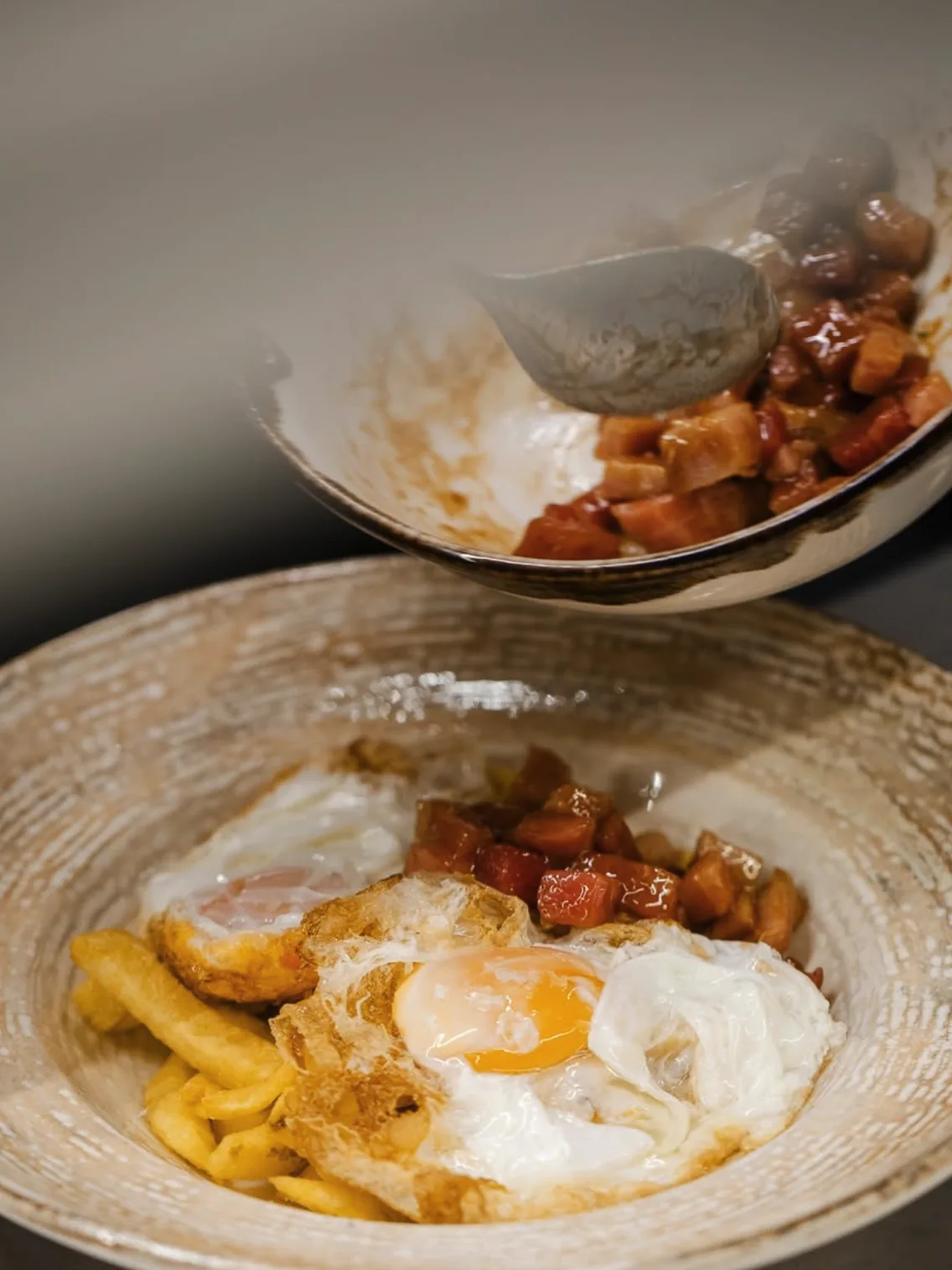 A bowl of fried eggs with potatoes and a spicy tomato sauce