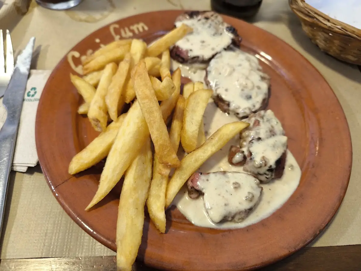 Pork with mushroom sauce and fries at Foc i Fum