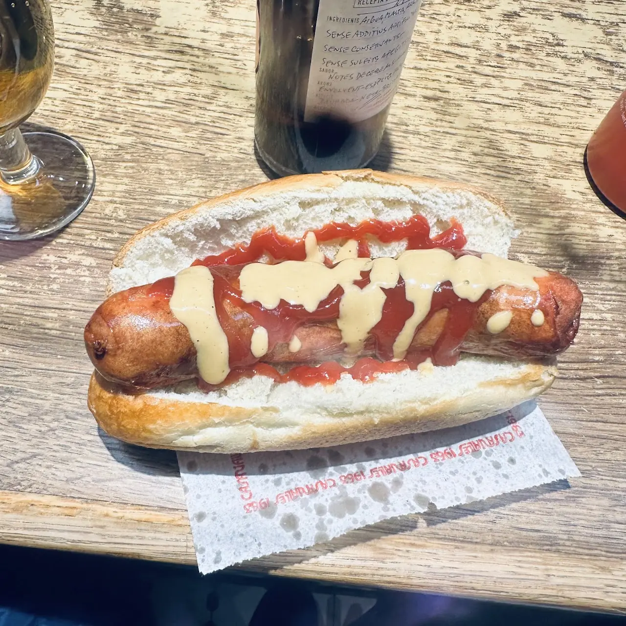Frankfurt sausage in a bread roll topped with fried onions and mustard, at Frankfurt Pedralbes.