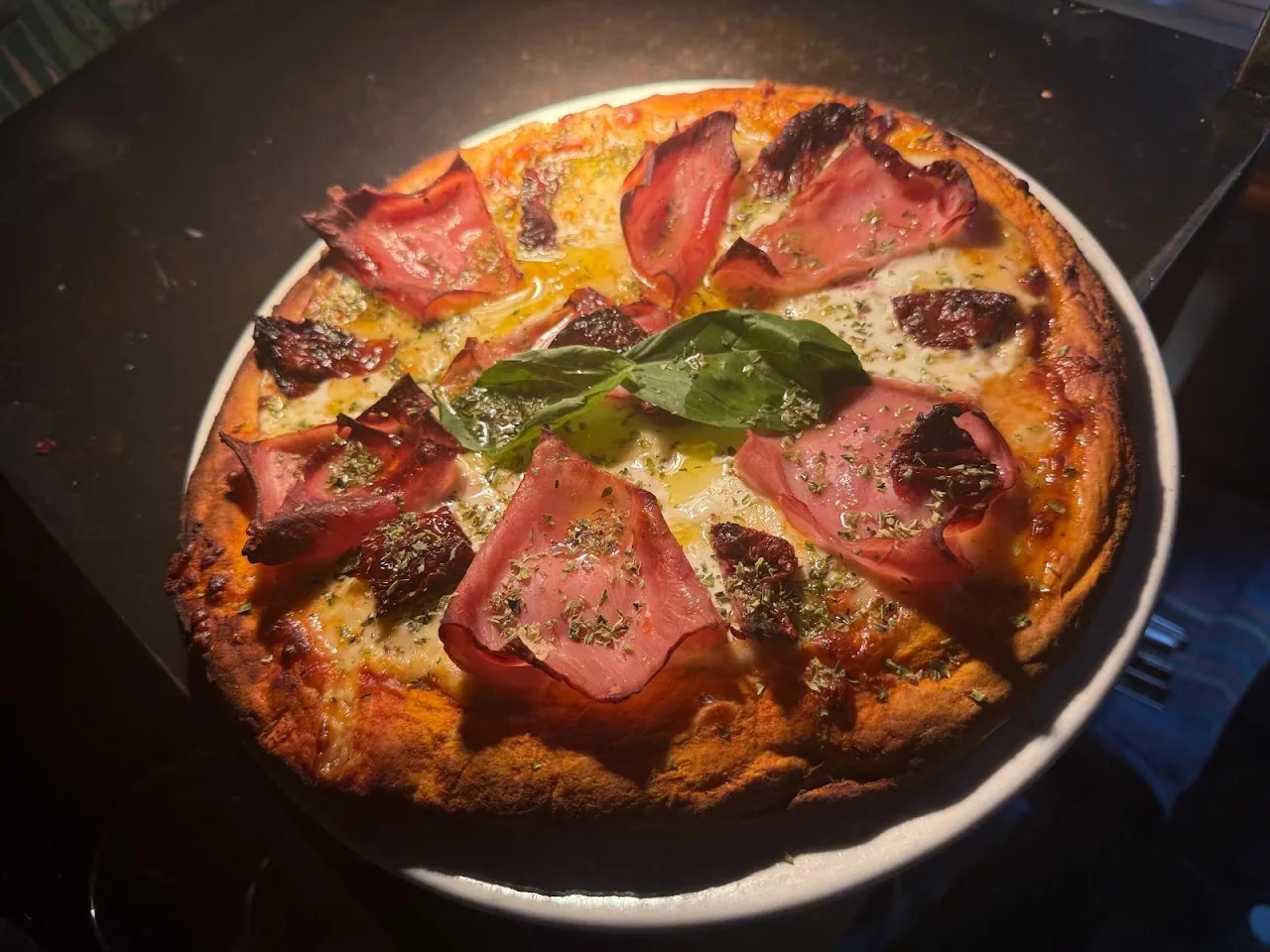 A round pizza topped with ham and green peppers