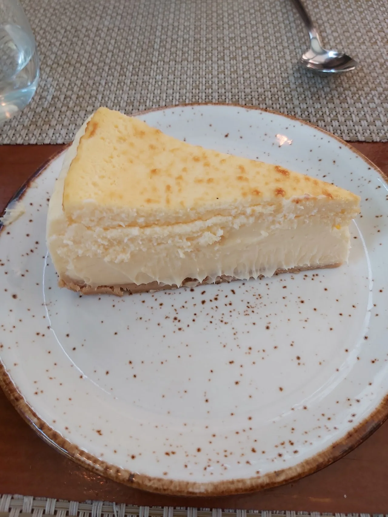 A slice of cheesecake on a plate with a spoon