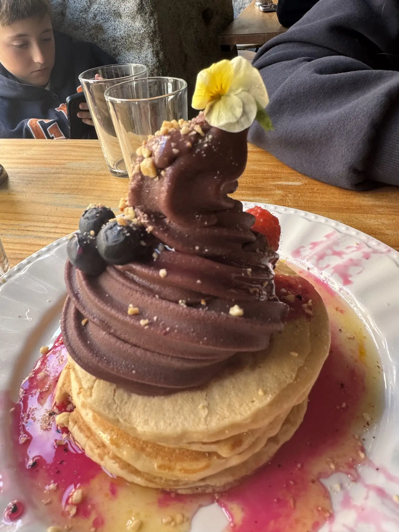 A stack of pancakes topped with a swirl of chocolate sauce.