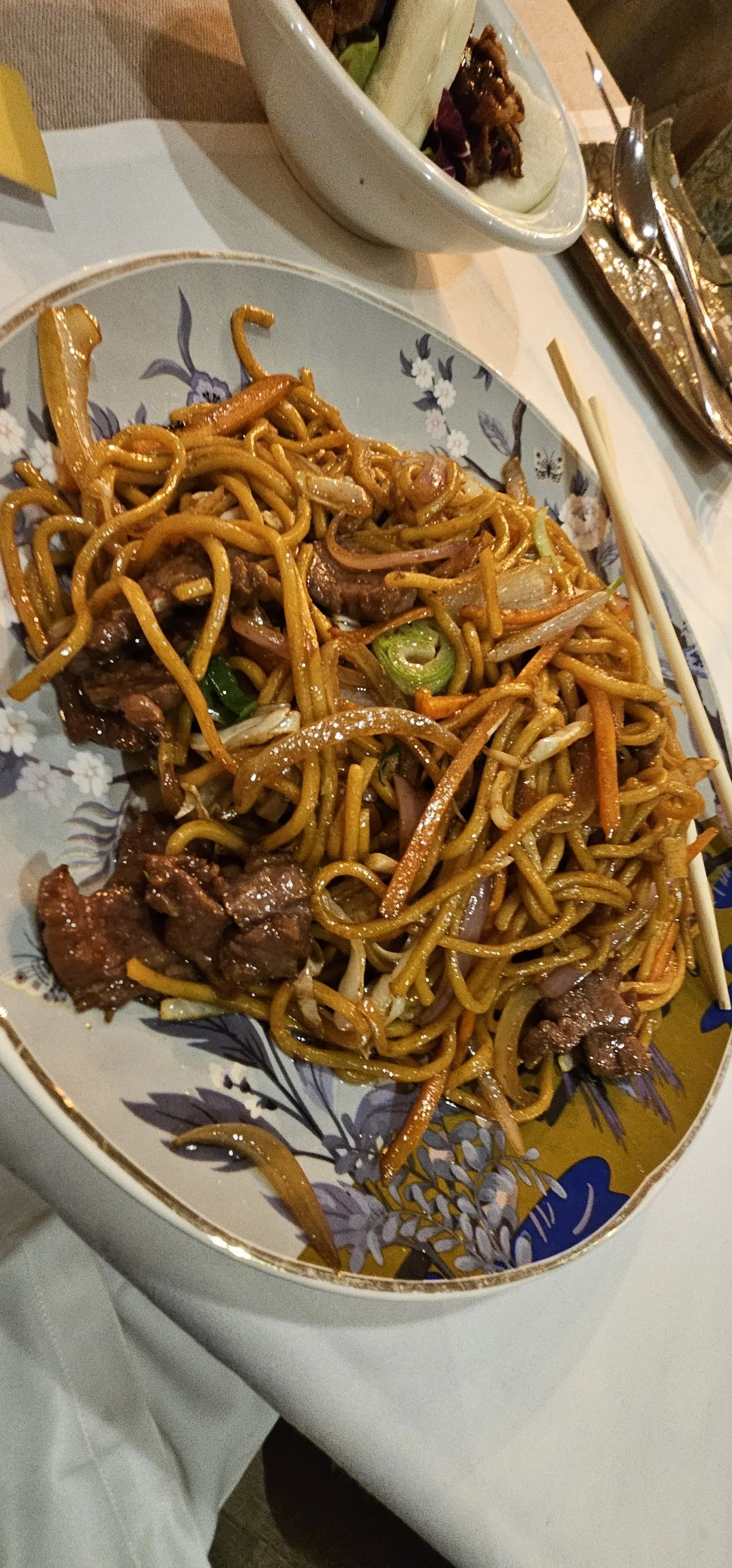 A plate of stir-fried lo mein noodles with vegetables
