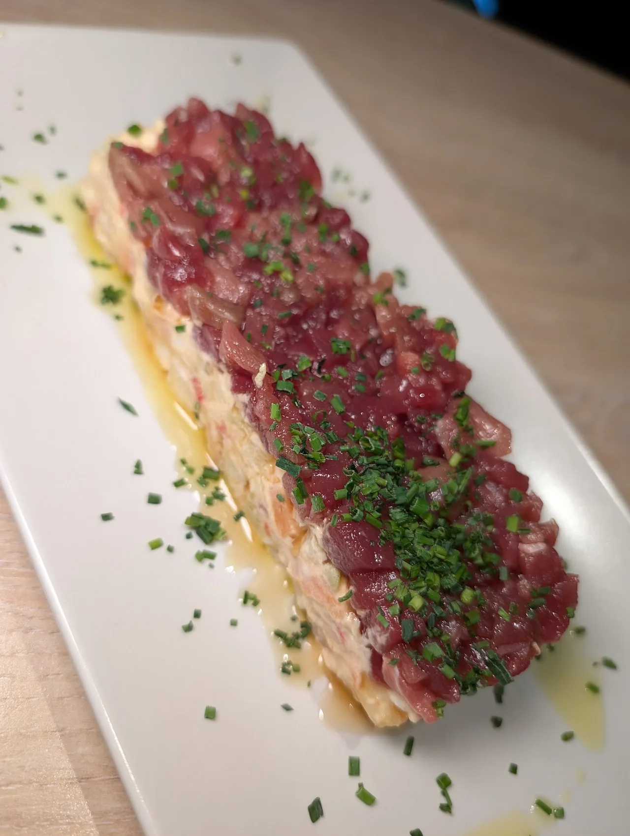 Thinly sliced cured beef carpaccio garnished with chopped herbs