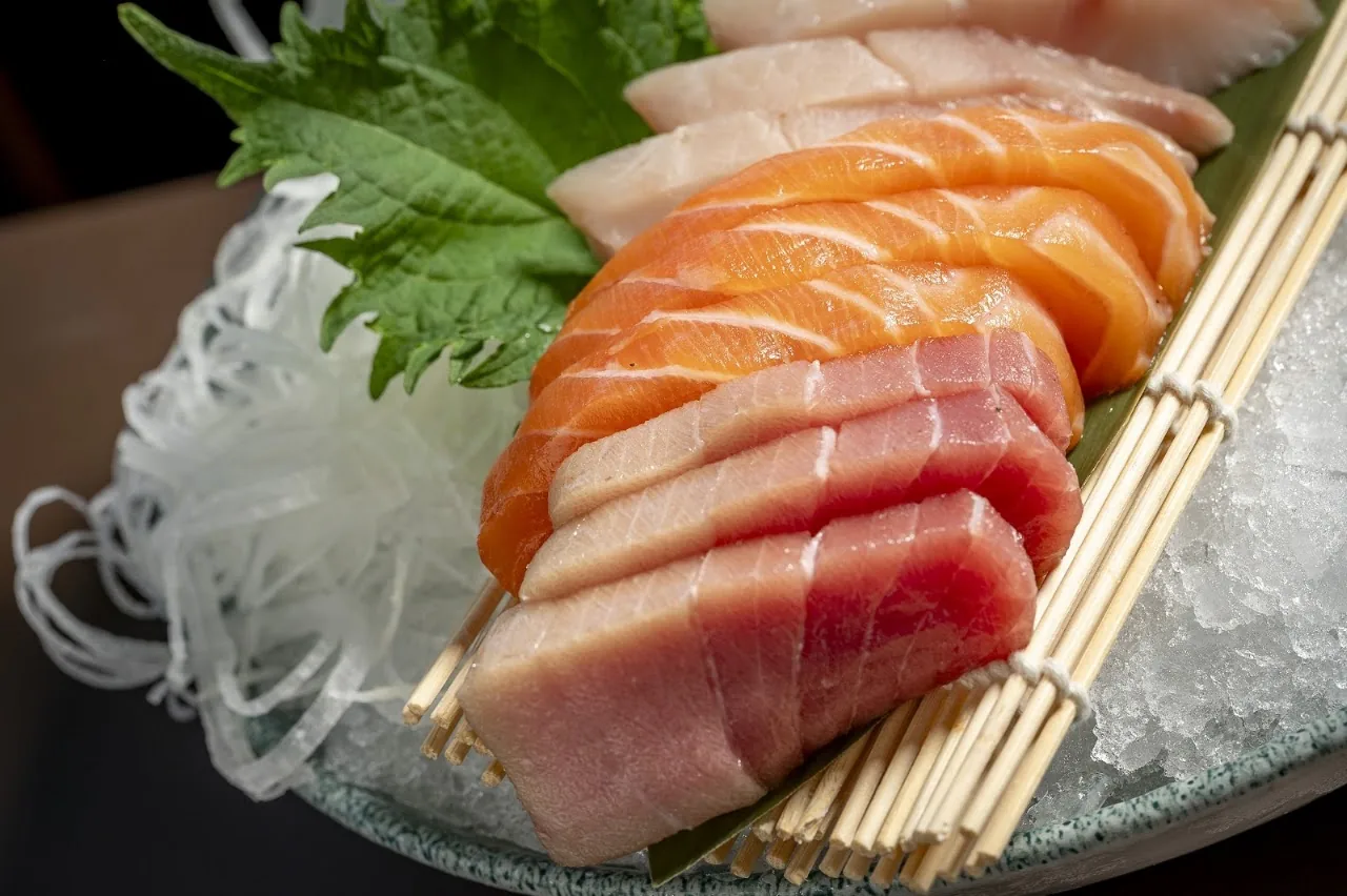 Slices of salmon and tuna sashimi arranged on a bed of shredded daikon