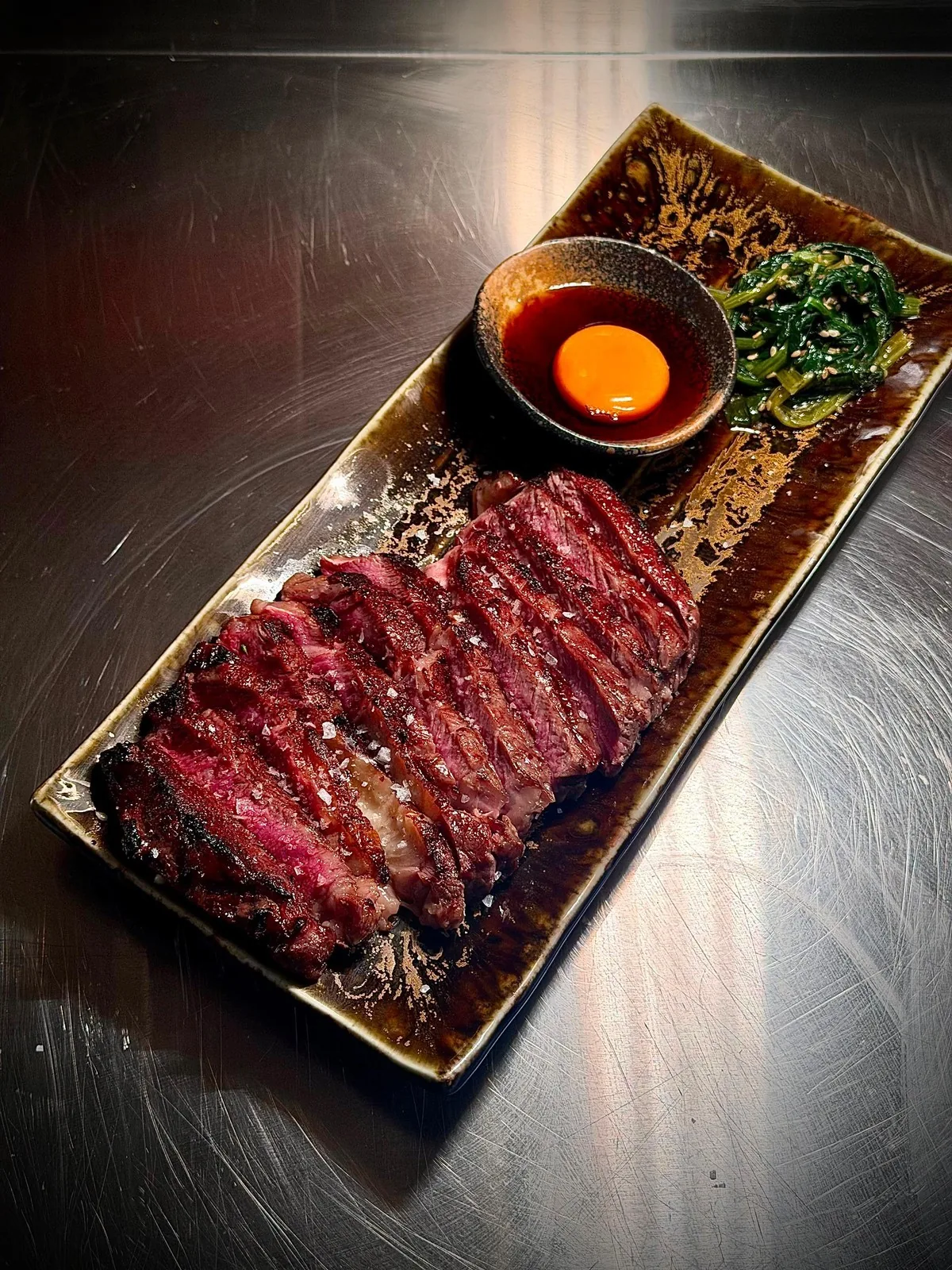 Sliced grilled beef served with a dipping sauce