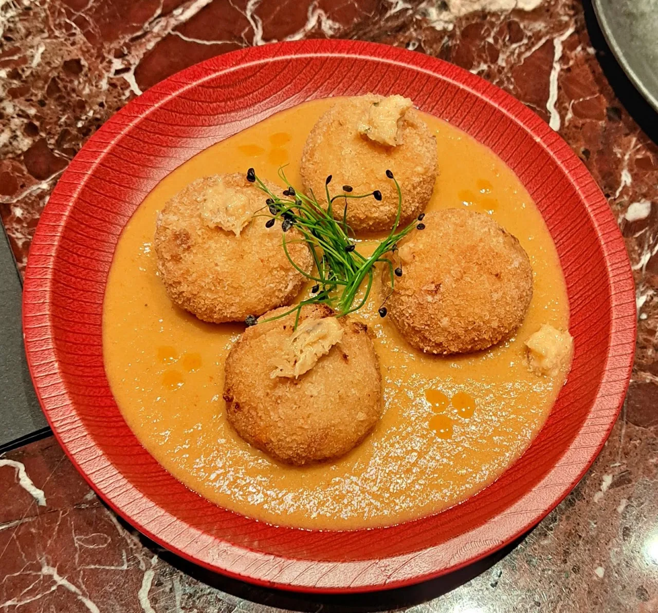 Fried croquettes served in a savory sauce