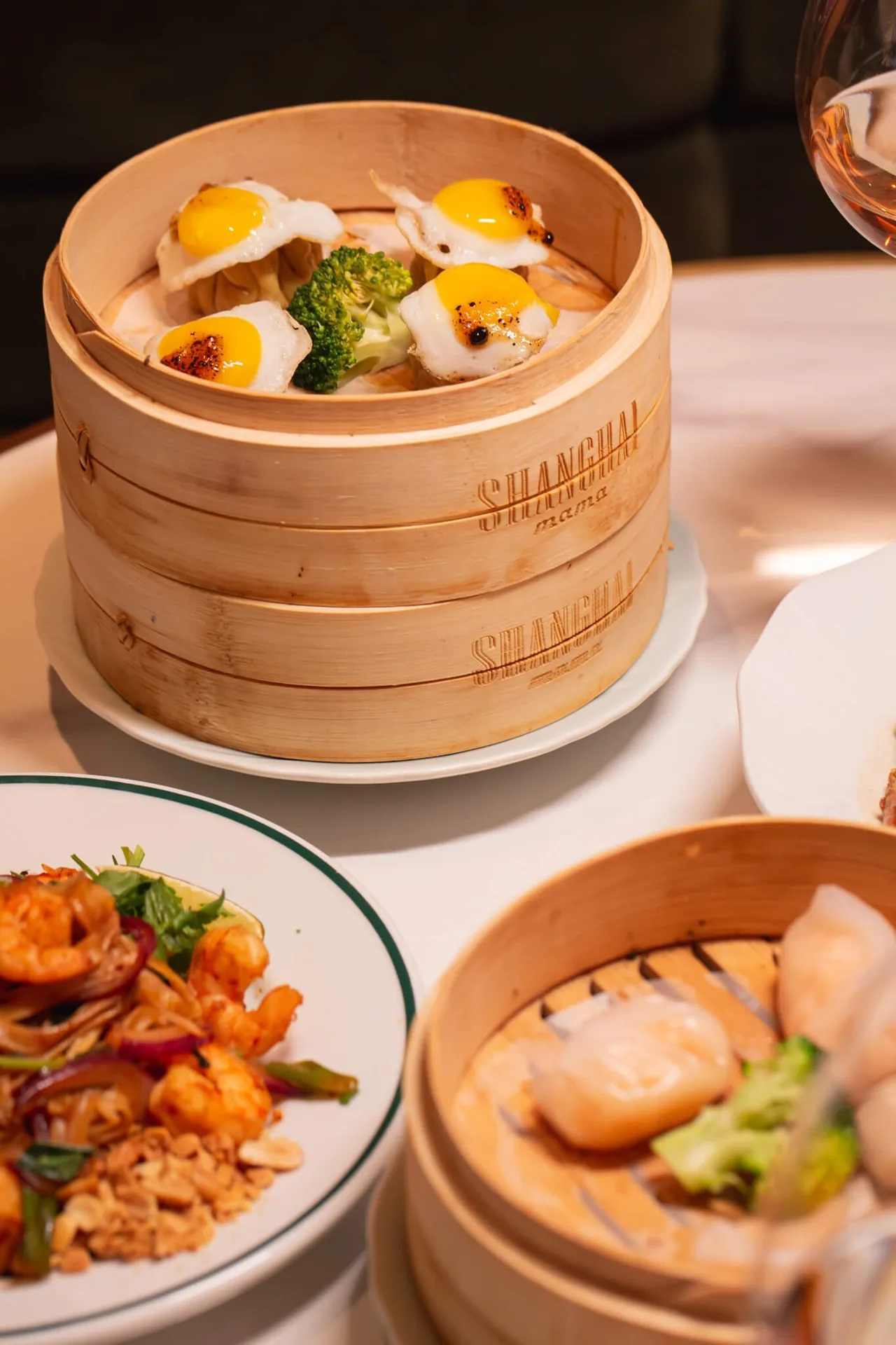 Stacked bamboo steamers with dumplings and plates of food