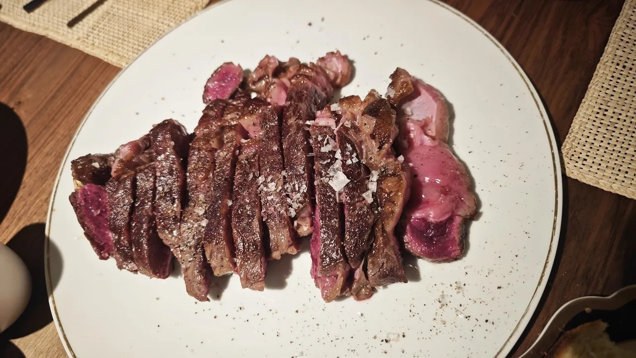 Sliced grilled steak on a white plate