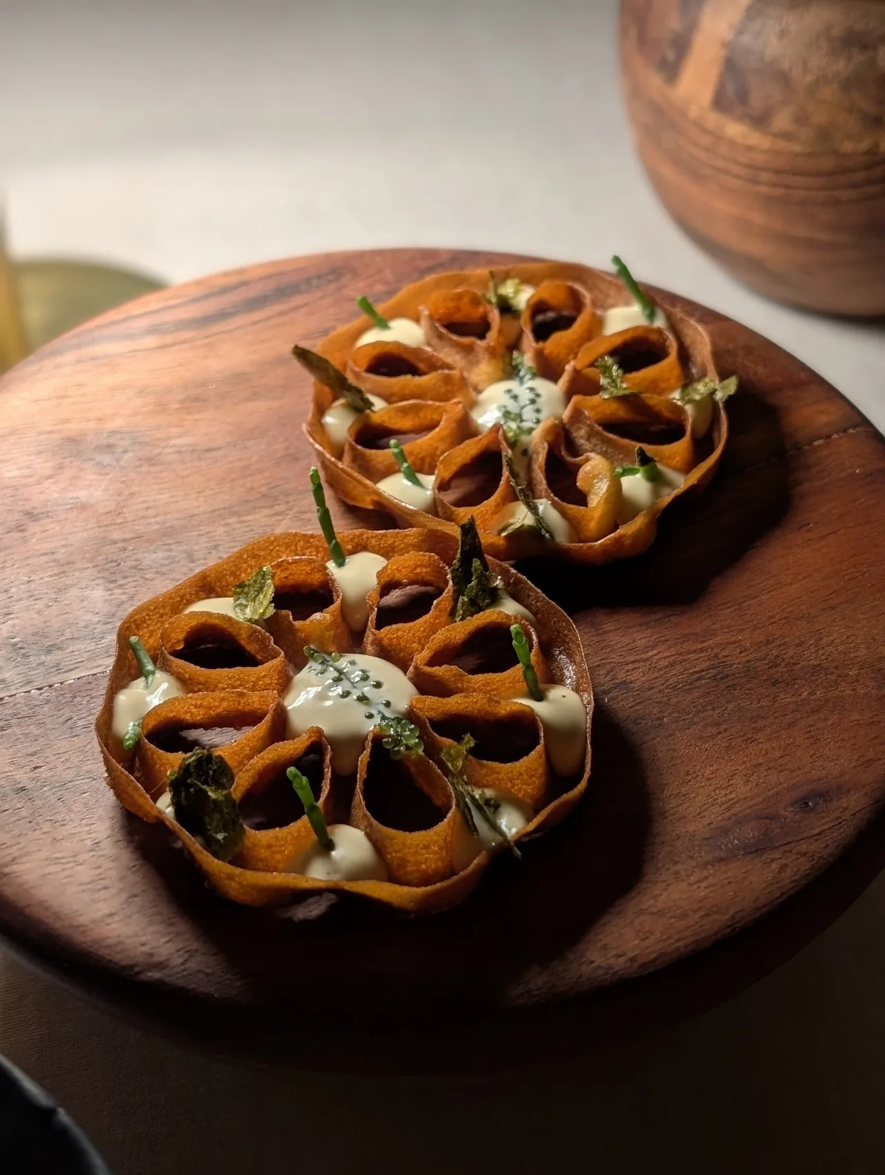 Two roasted vegetable halves with toppings on a wooden board