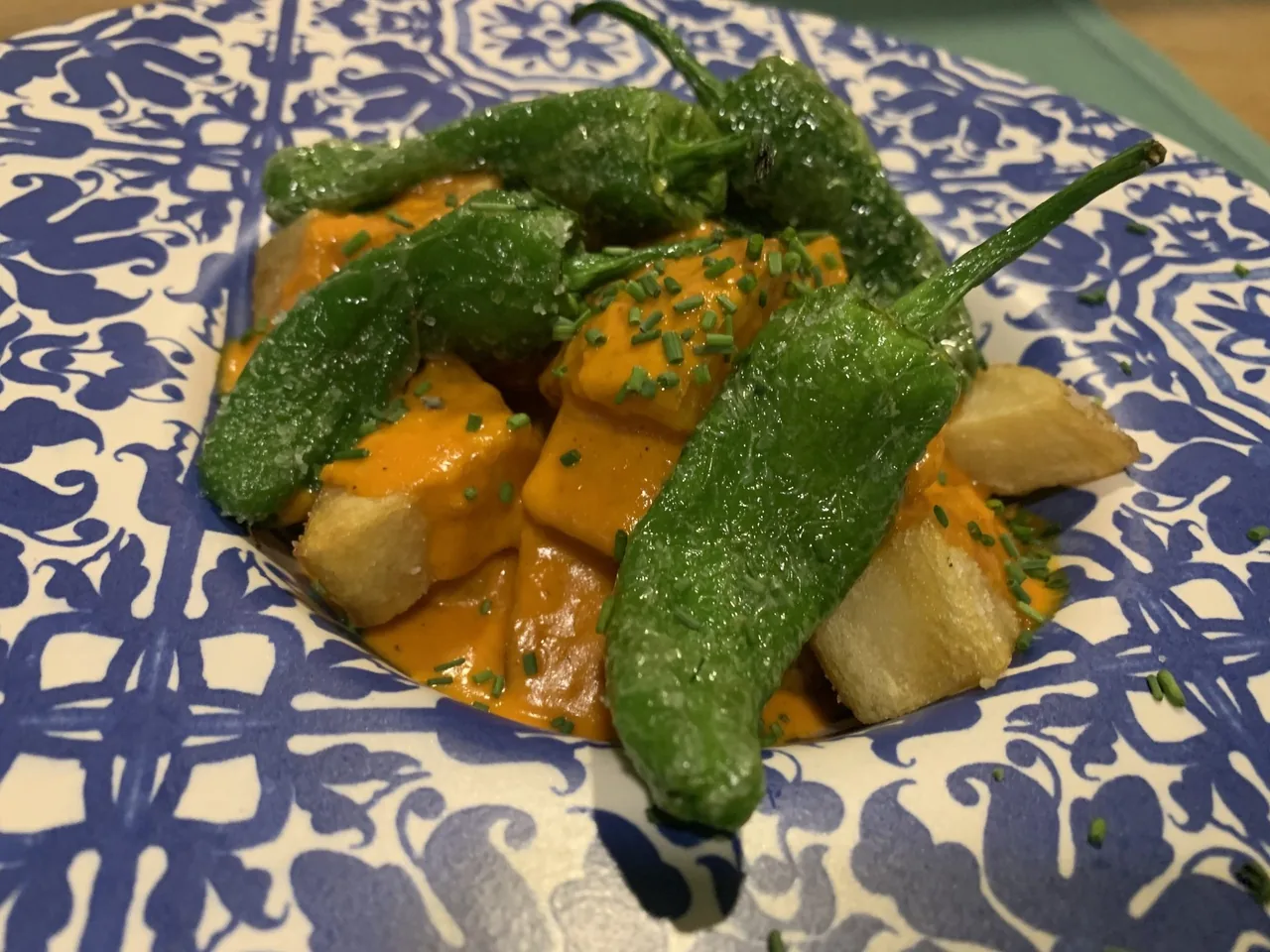 Chunks of orange squash and green peppers on a blue and white patterned plate