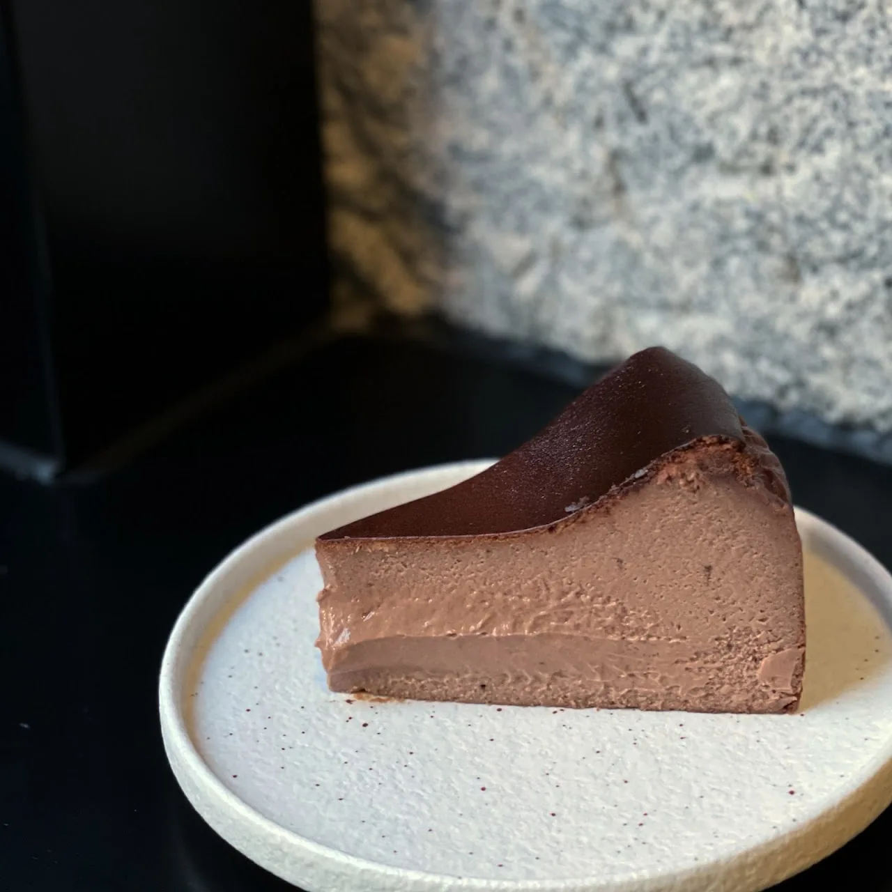 A slice of dark chocolate mousse cake on a plate