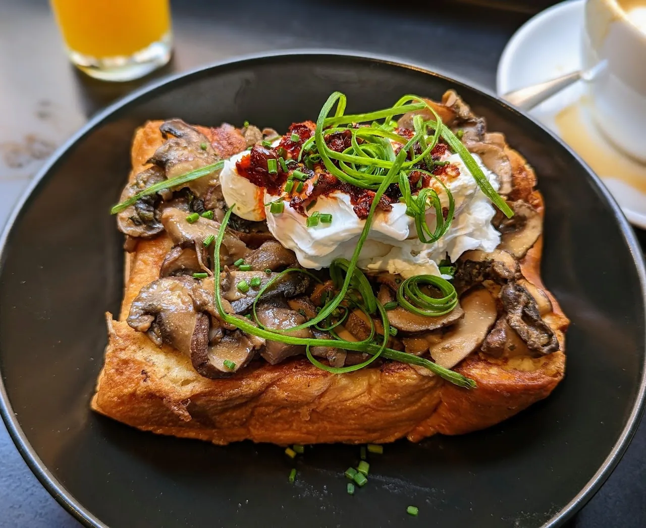A toast topped with sauteed mushrooms and microgreens
