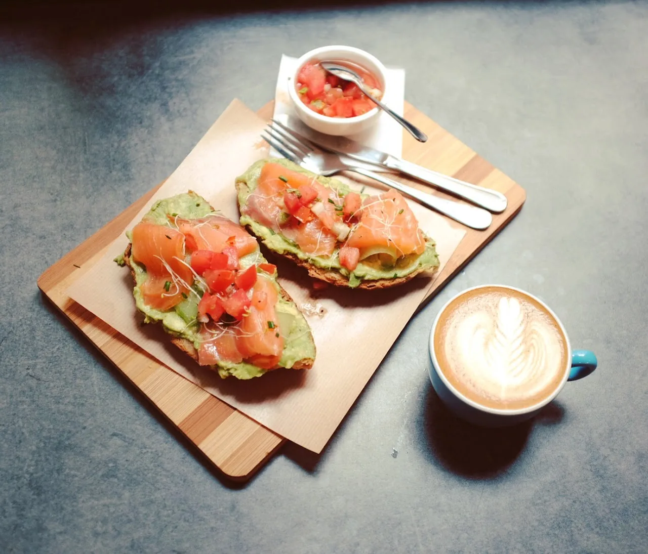 Avocado toast with a poached egg and a coffee on the table