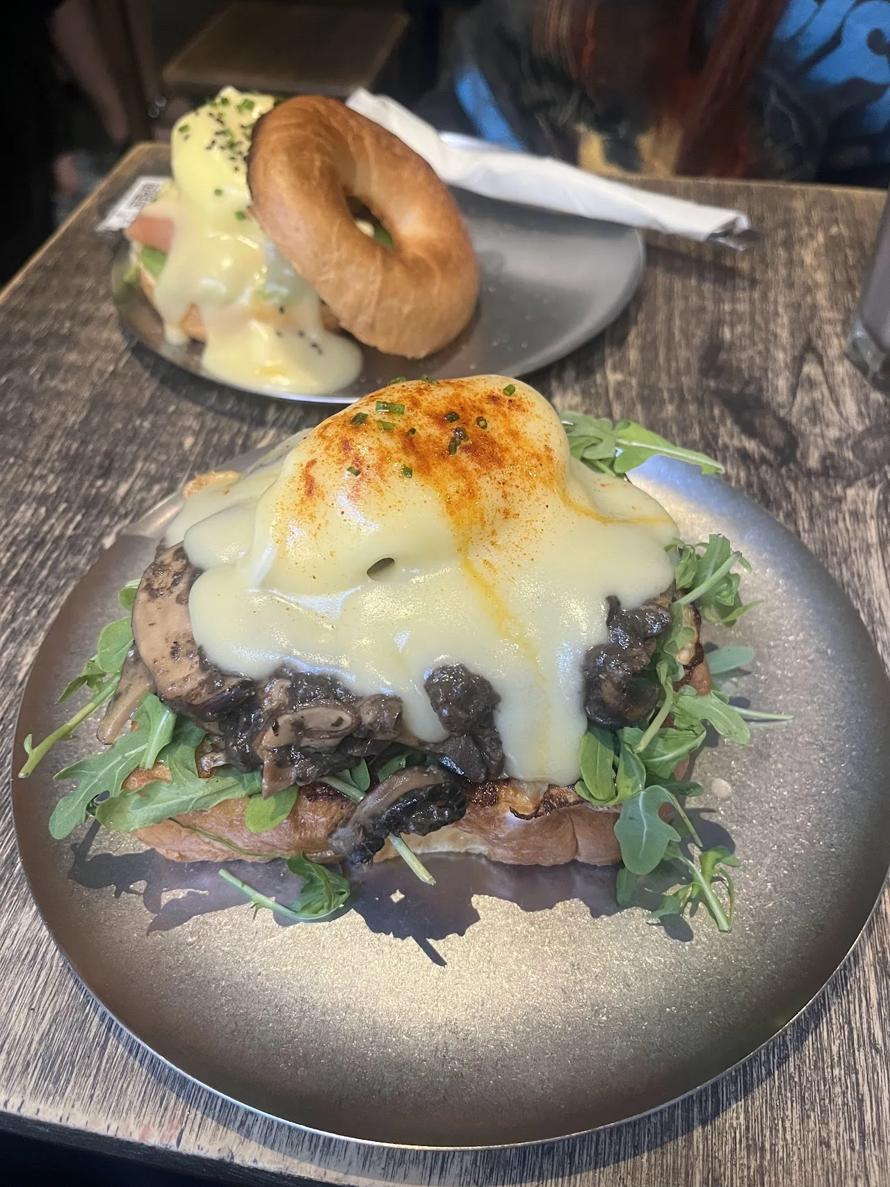 Overhead view of a bagel sandwich and a mushroom toast on plates