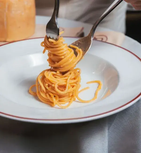 Forkfuls of spaghetti al pomodoro lifted from a white rimmed plate at Harry's