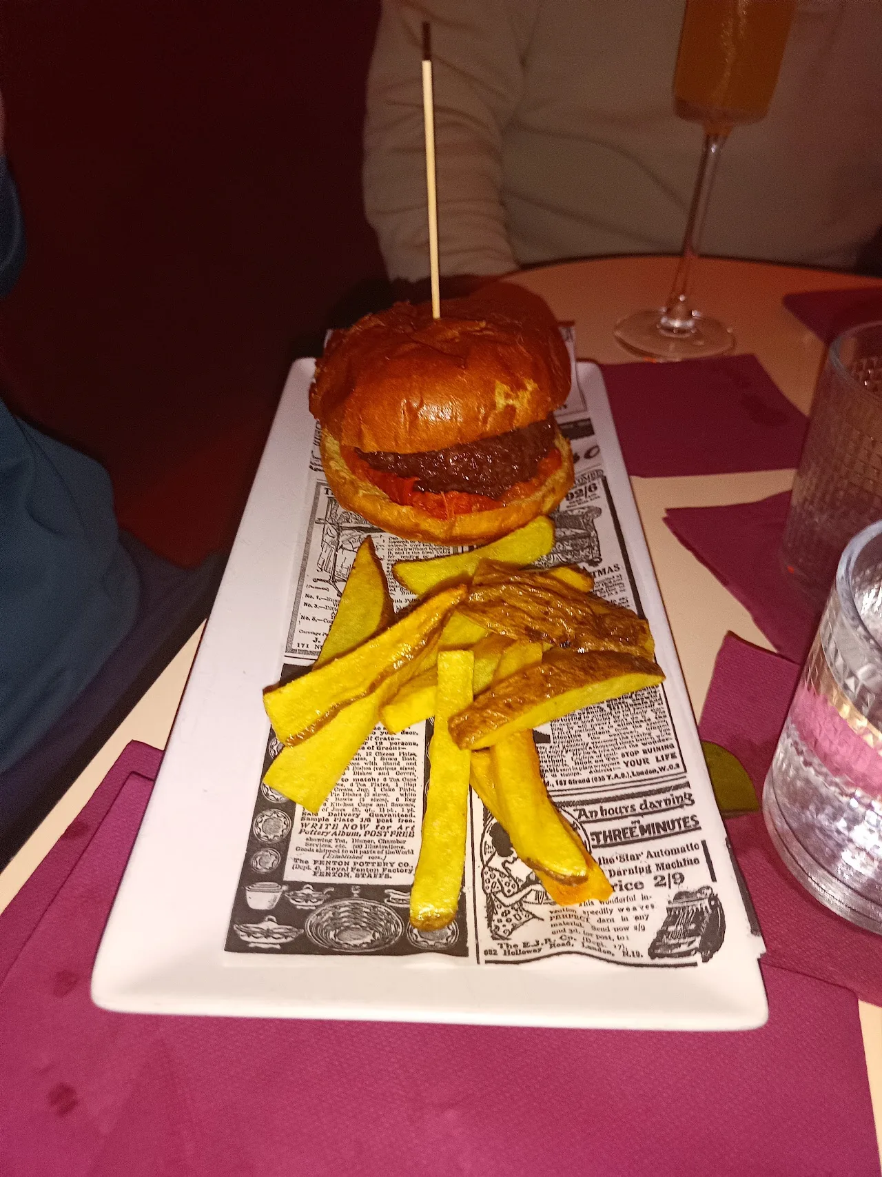 A sliced burger and fries served on a plate
