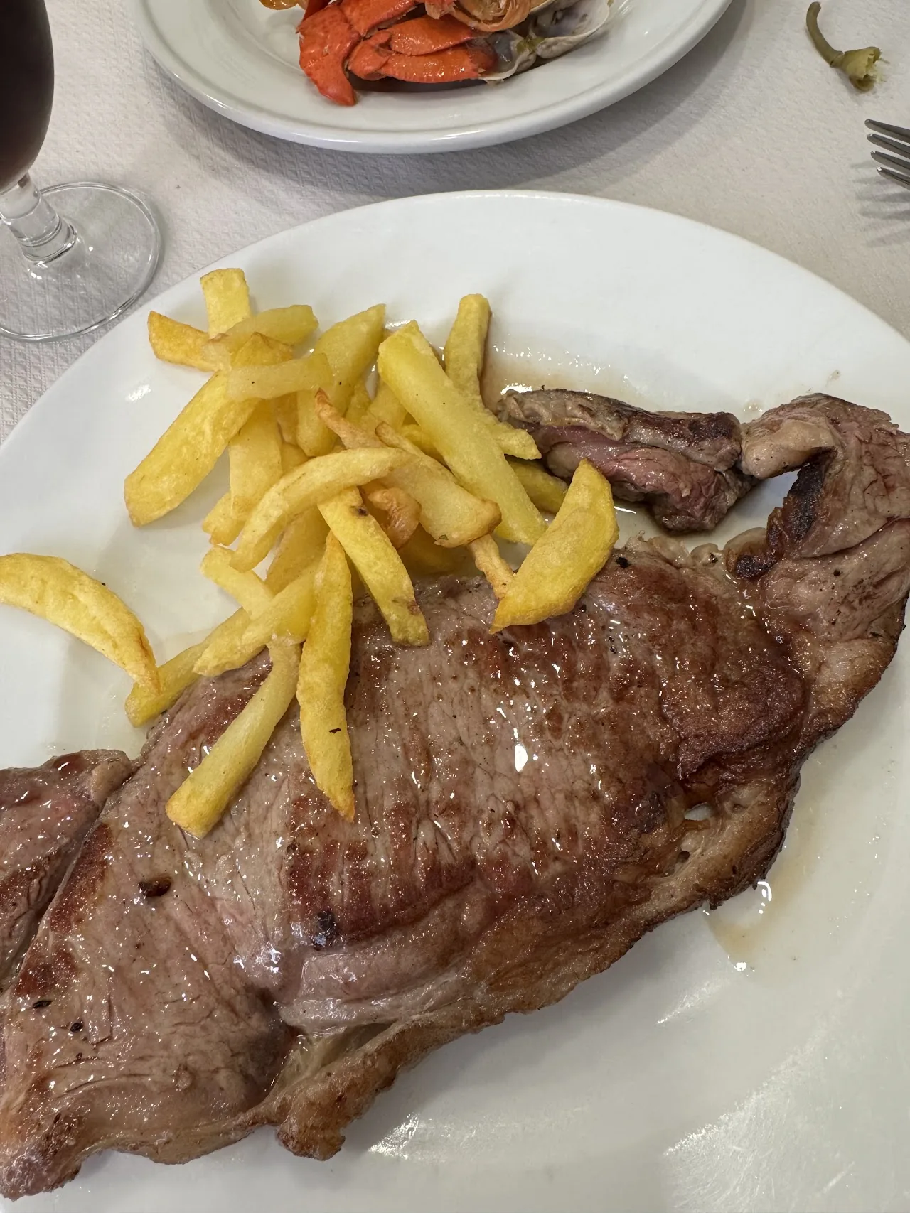 A grilled steak with a side of French fries
