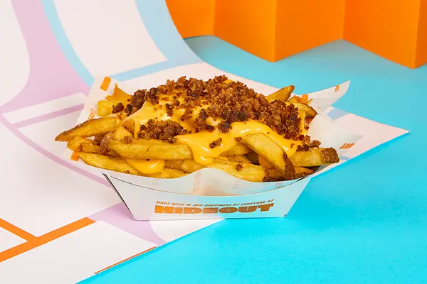 Cheese fries topped with melted cheddar sauce and crispy bacon bits at Hideout Burger