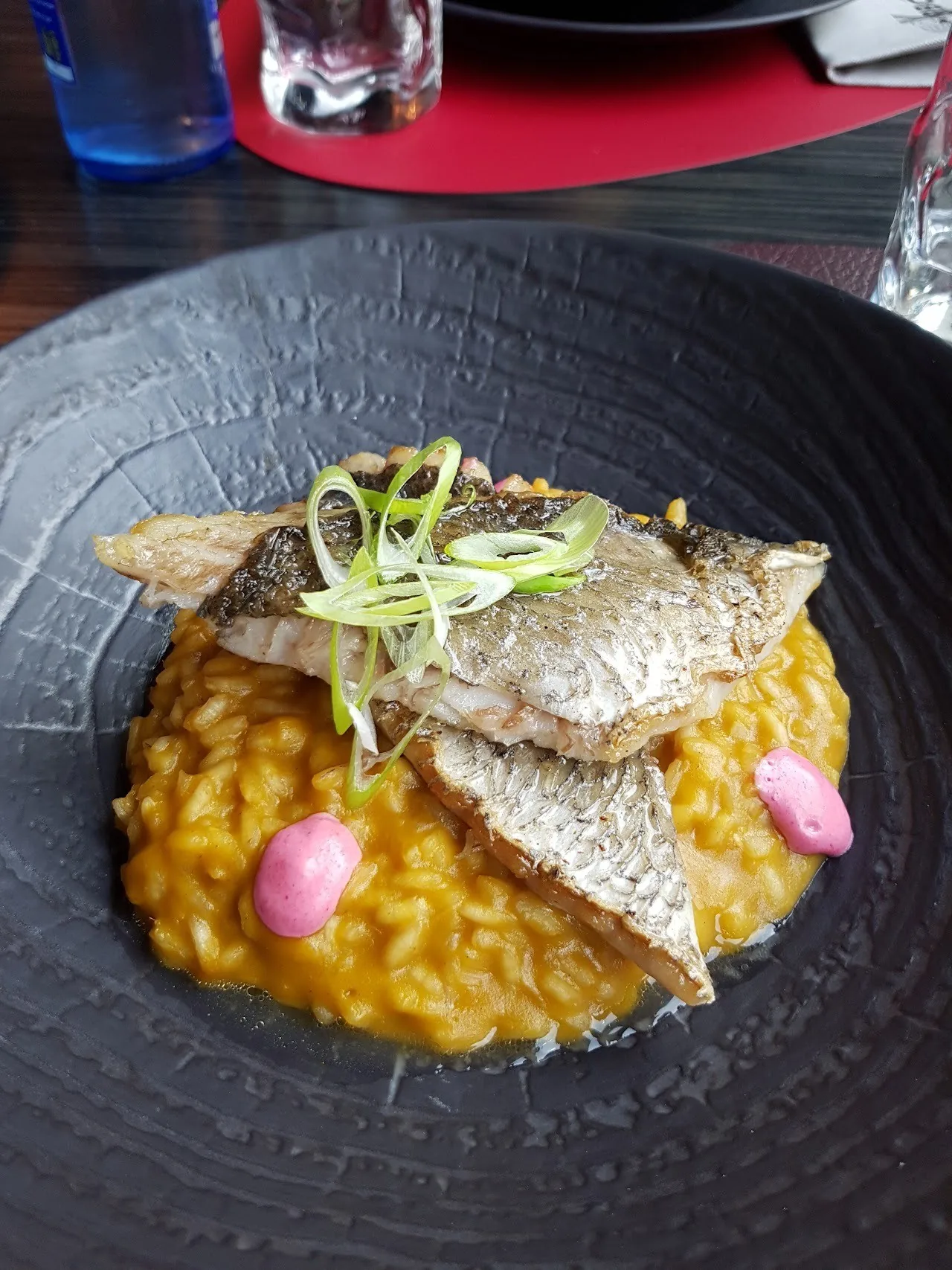 Rice with pieces of fish on a dark round plate